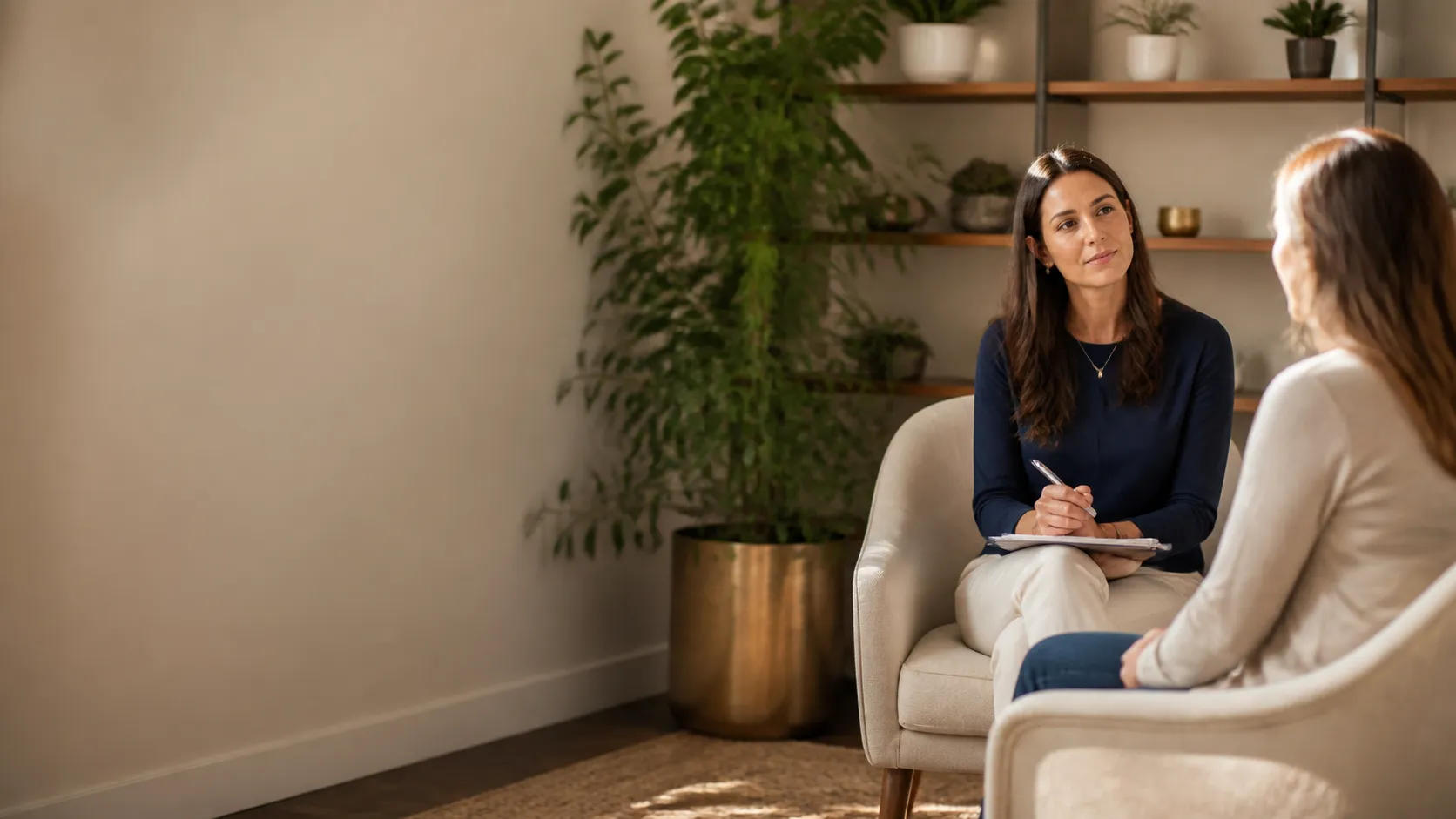 Practitioner and patient talk in a warm functional medicine office with plants and open shelving.